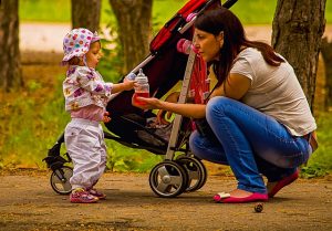 Esernyőbabakocsi-anya-gyermekével-a-parkban